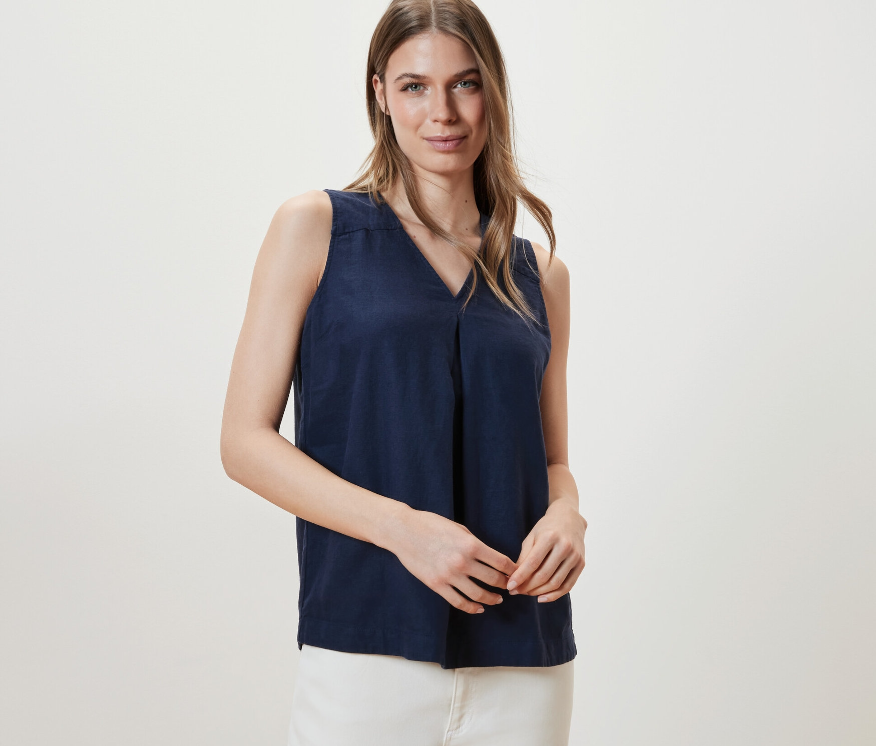 Frau posiert in ärmelloser Leinenbluse, navy.