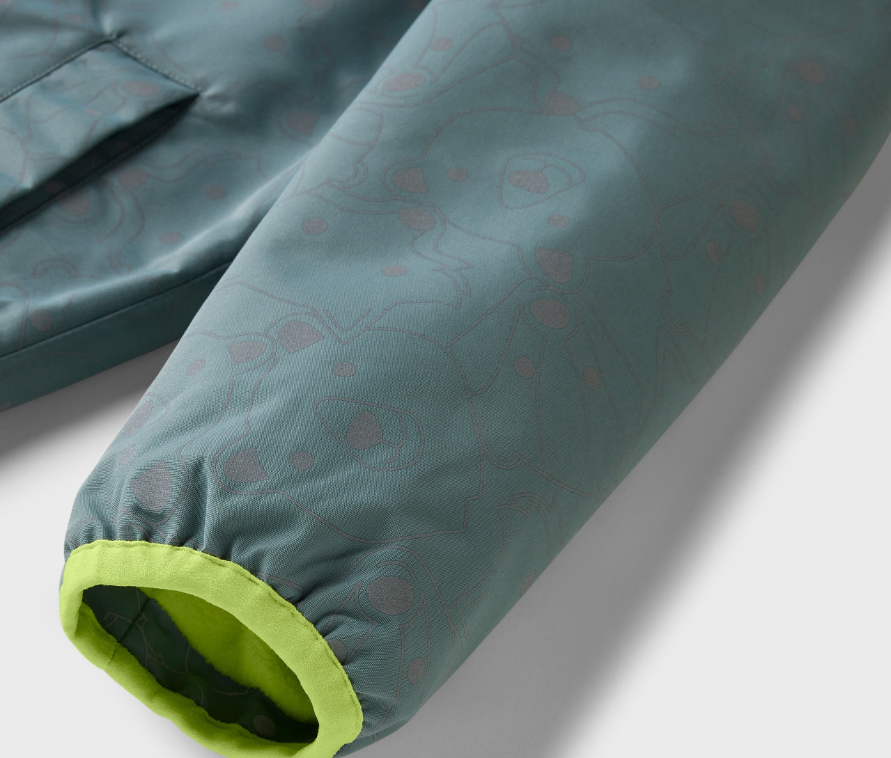 Detail einer Kinder-Thermo-Regenjacke mit reflektierenden Elementen.