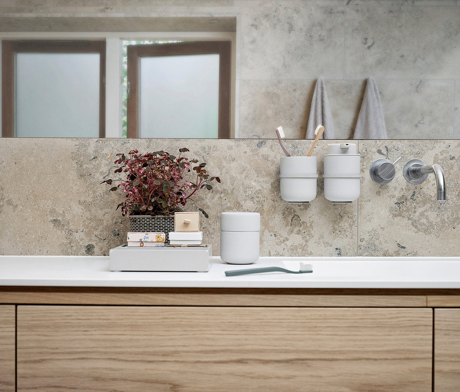 Badezimmer mit Waschbecken, darauf ein hellgrauer ZONE DENMARK Seifenspender »Ume«, eine Pflanze und Accessoires.