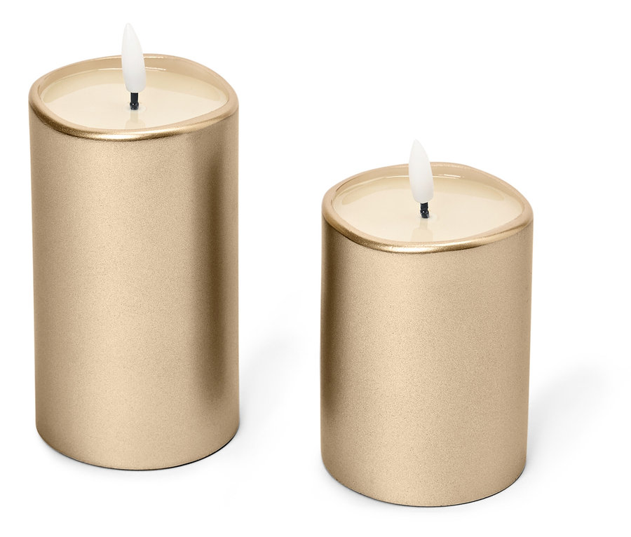 Zwei goldene Kerzen stehen auf einem weißen Hintergrund.