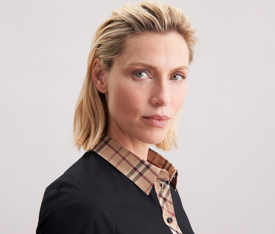 Frau trägt eine Seidensticker Popeline-Bluse mit Karodetail.