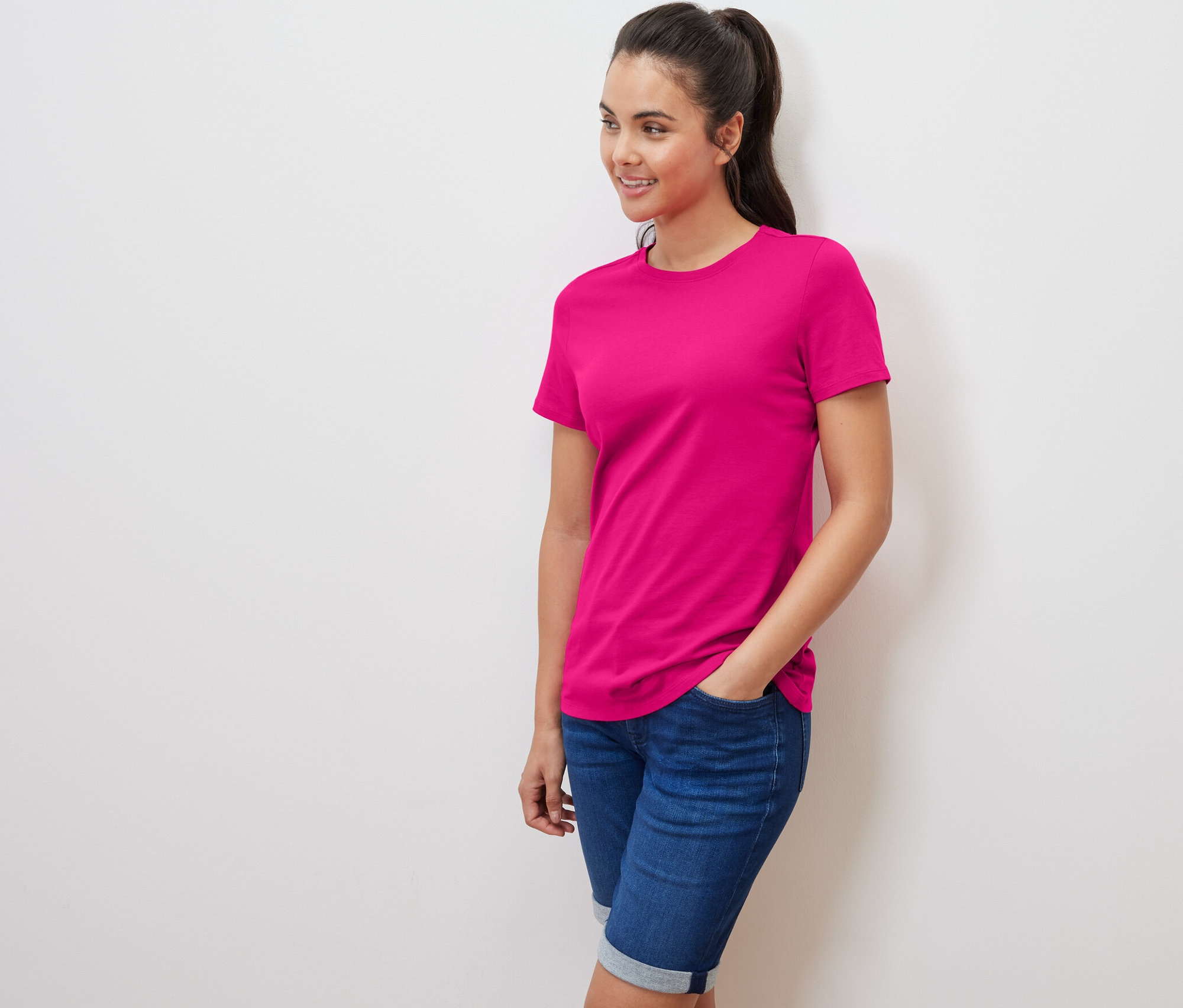 Frau posiert mit einem pinken T-Shirt.