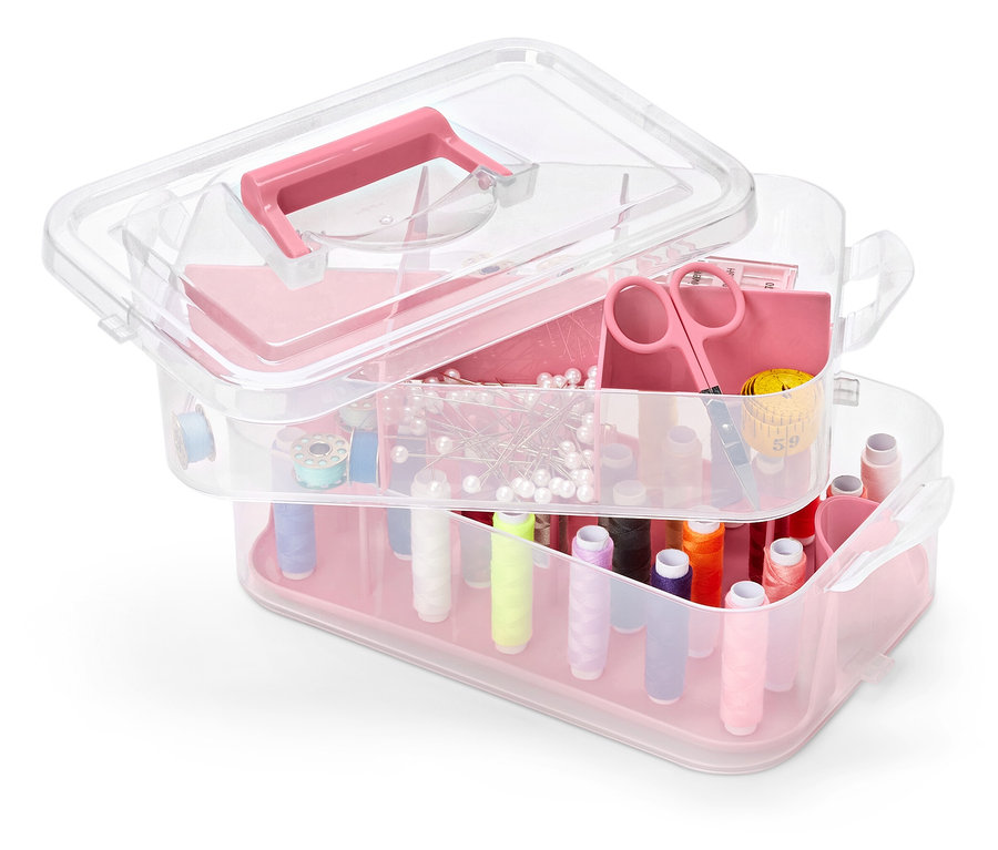 Ein mehrstöckiger, durchsichtiger Werkzeugkasten aus Kunststoff mit rosa Akzenten, gefüllt mit Nähzubehör.