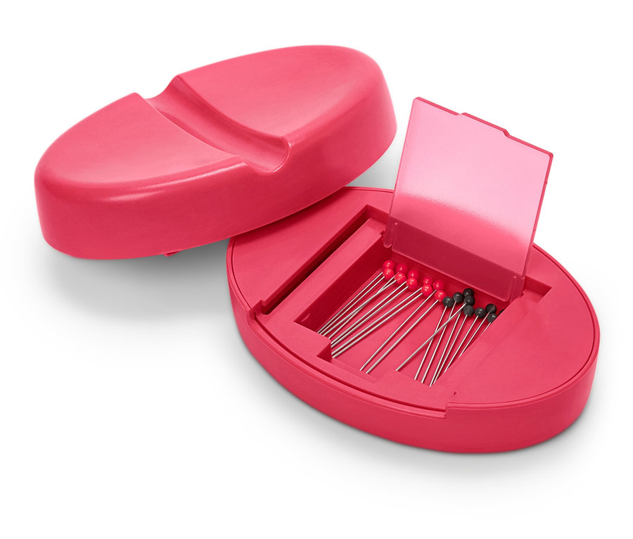 Geöffnetes, pinkfarbenes magnetisches Nadelkissen mit Nadeln darin.