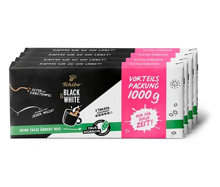 Vier Packungen Tchibo Black & White gemahlener Kaffee, jede Packung enthält 1 kg Kaffee.
