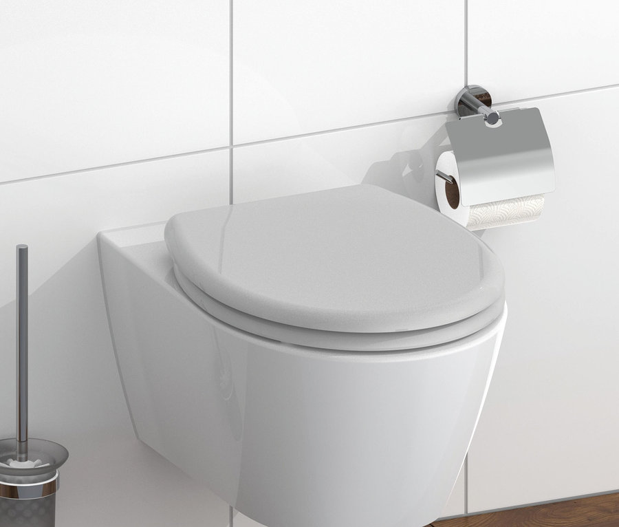 Weiße, wandhängende Toilette mit Toilettenpapier und WC-Bürste.