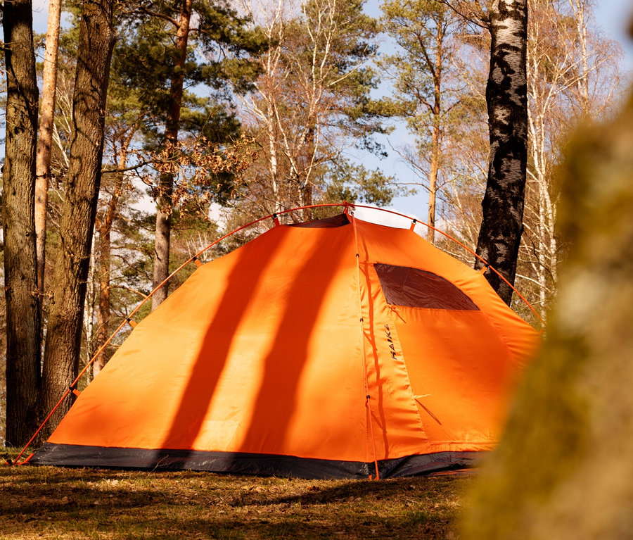 Orangefarbenes Tambu Haika 3-Personen-Kuppelzelt im Wald.