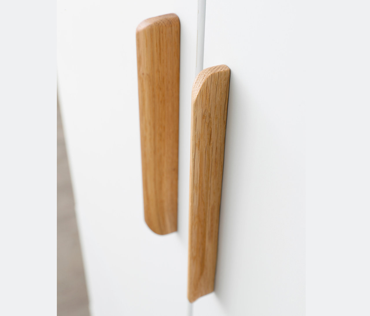 Detailansicht von zwei Holzgriffen an einem weißen rauch Kleiderschrank »Quadra-Spin«.