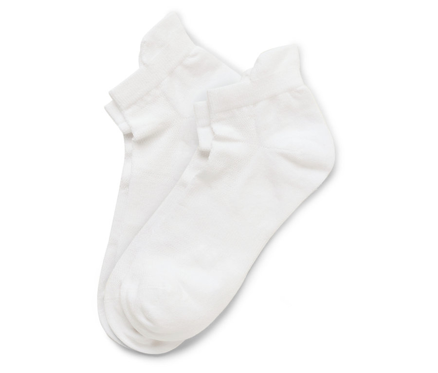 Zwei weiße Socken liegen übereinander auf einem weißen Hintergrund.