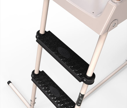 Nahaufnahme der schwarzen Stufen mit Wabenmuster einer beigen Kinderleiter, die an einem Hochstuhl befestigt ist.