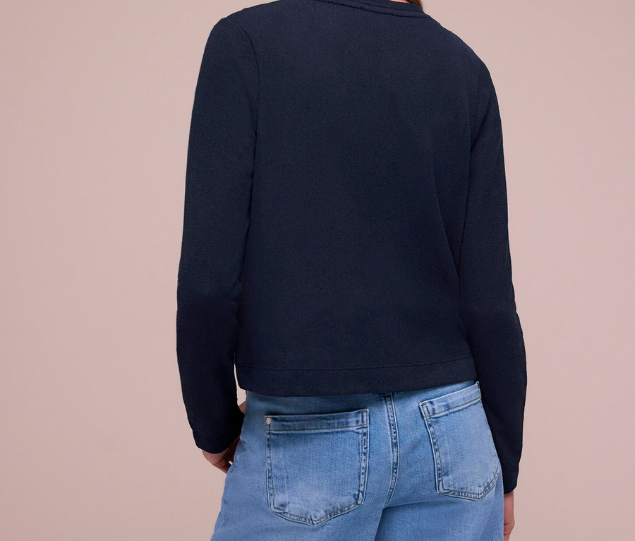 Frau von hinten, trägt einen dunkelblauen Street One Cardigan und hellblaue Jeans.