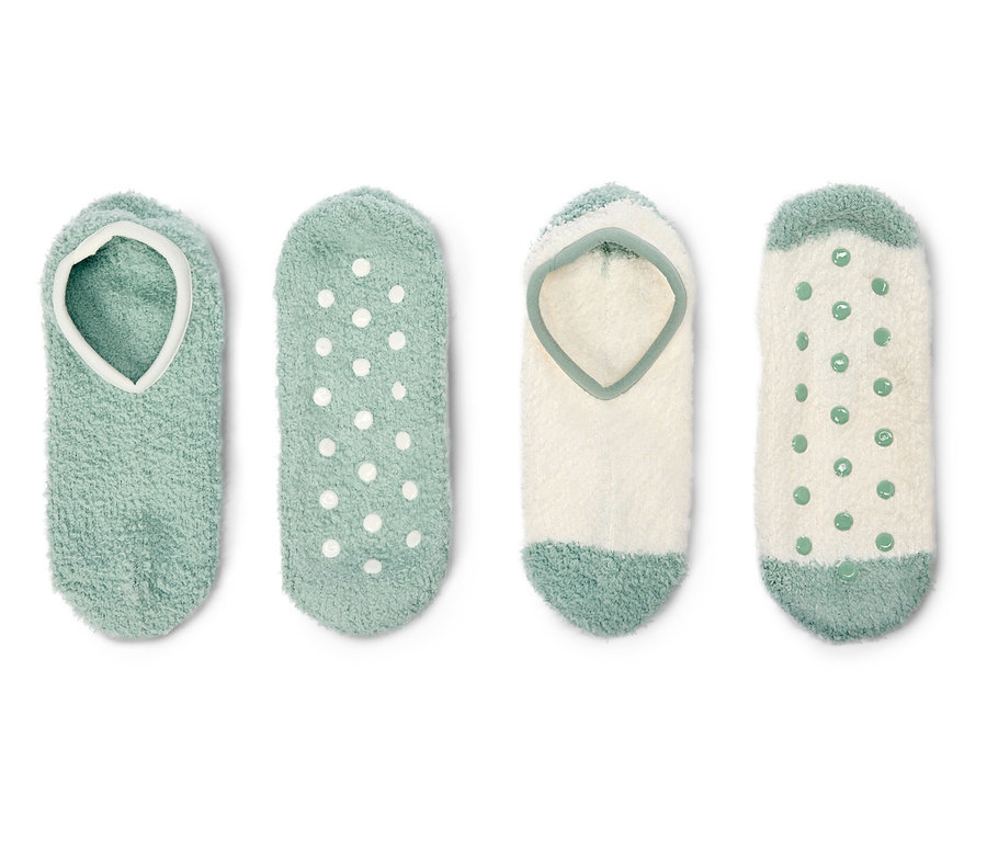 Vier flauschige Sockenpaare in Grün und Weiß liegen auf einem weißen Hintergrund.