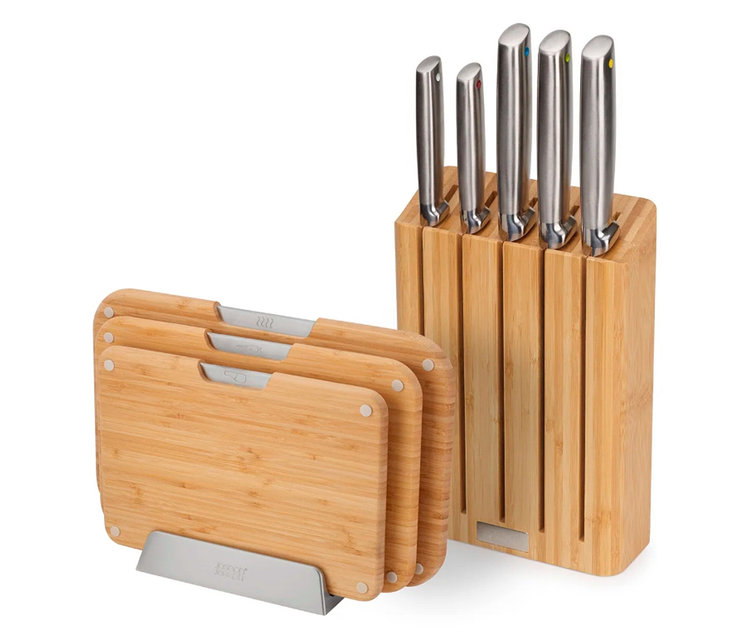 Joseph Joseph Schneidebretter und Messerblock aus Holz stehen auf einer weißen Oberfläche.