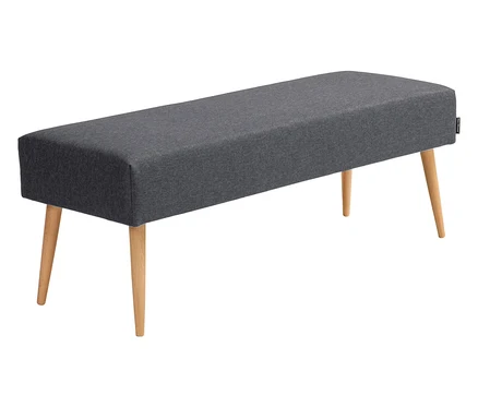 Ein grauer, gepolsterter Hocker mit vier Holzbeinen steht auf einem weißen Hintergrund.