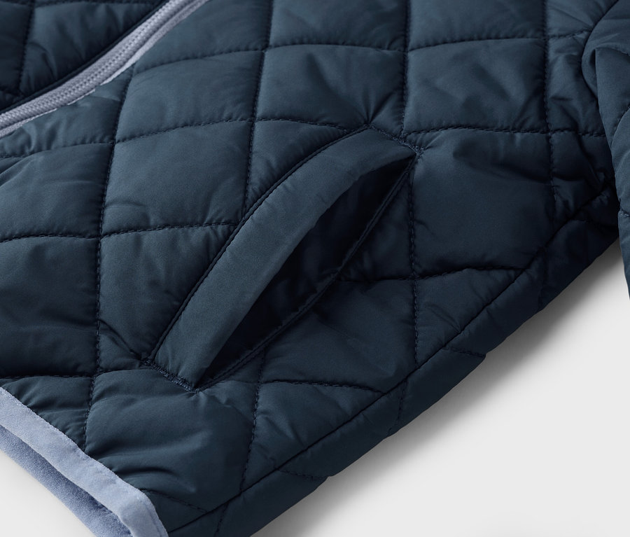 Detailaufnahme einer dunkelblauen Steppjacke mit einer Tasche.