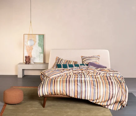 Schlafzimmer mit einem Bett mit Essenza Satin-Bettwäsche »Donna« in Normalgröße mit Streifenmuster und Kissen.