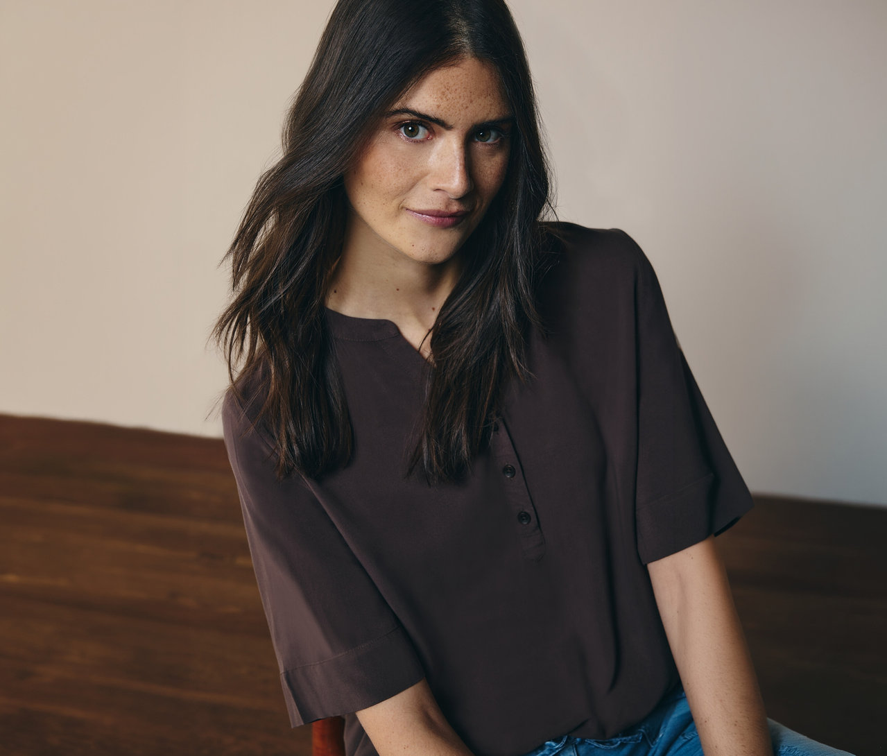 Frau trägt eine braune CECIL Tunikabluse mit Knöpfen und Jeans.