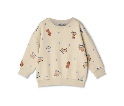 Cremefarbenes Kinder-Sweatshirt mit langen Ärmeln und einem Muster aus Cartoon-Hunden auf Skateboards und kleinen blauen Punkten.