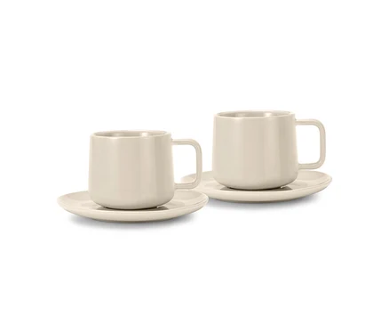 Zwei beige Kaffeetassen mit Untertassen.