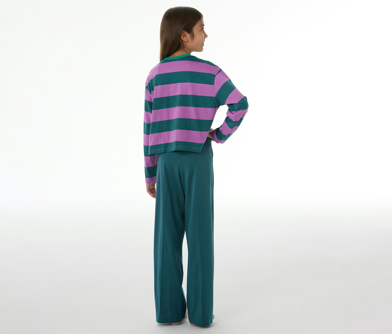 Kind von hinten, das einen SCHIESSER Kinder-Pyjama trägt, bestehend aus einem lila-grün gestreiften Langarmshirt und einer grünen Hose mit weitem Bein.