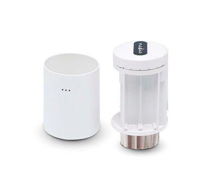 Zwei weiße zylindrische Objekte auf weißem Hintergrund: ein geschlossener Behälter mit drei Punkten und ein "nedis" Batteriedispenser mit transparenten Schlitzen und silbernem Boden.