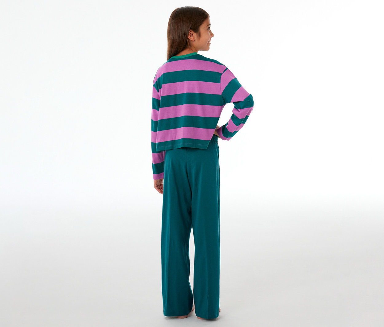 Mädchen von hinten in einem SCHIESSER Kinder-Pyjama mit pink-grün gestreiftem Oberteil und grüner Hose.