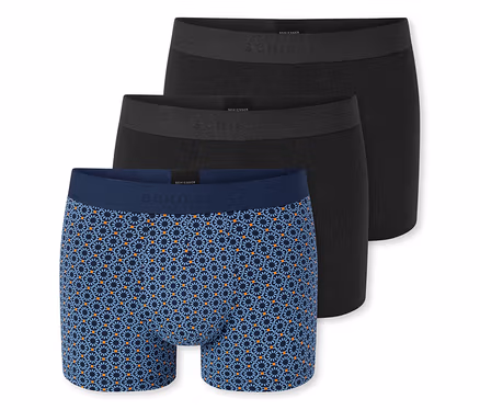 Drei Herren-Boxershorts, zwei davon einfarbig dunkelgrau und eine hellblau mit dunkelblauem und orangefarbenem geometrischem Muster, gestapelt auf weißem Hintergrund.
