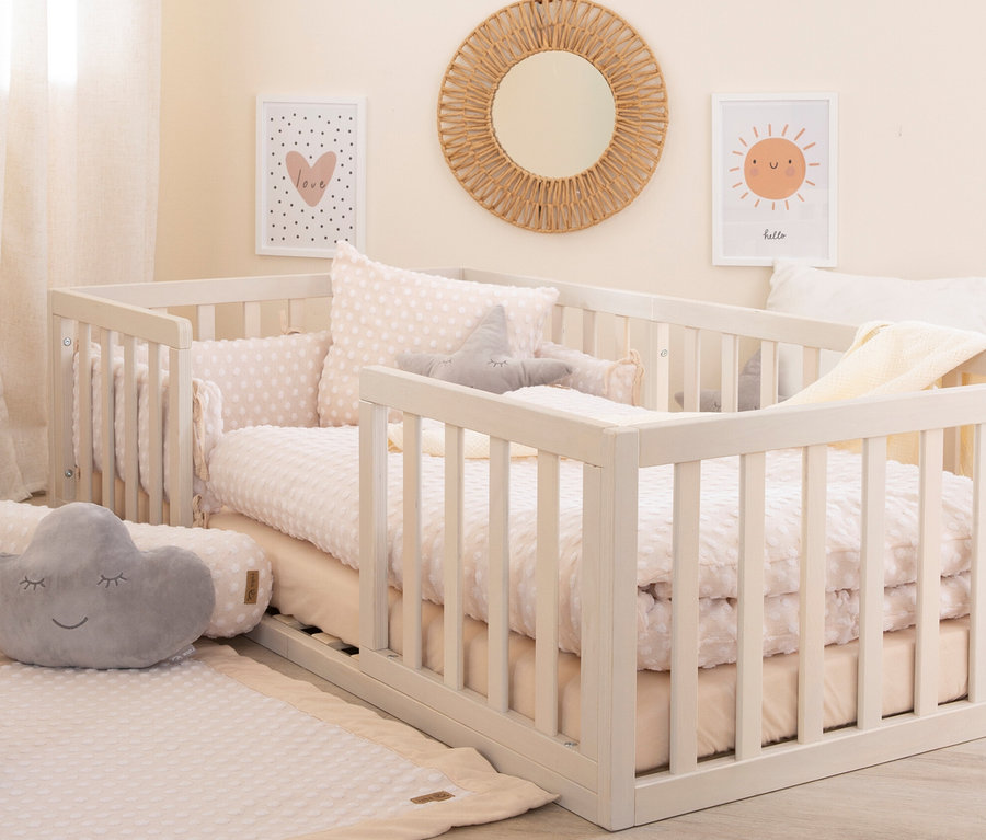 Weißes roba Bodenbett 70 x 140 cm mit Kissen und Spielzeug in hellem Kinderzimmer.