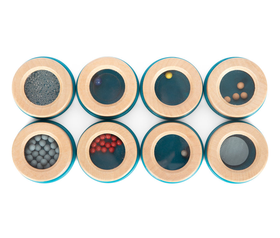 Acht hölzerne sensorische Pucks small foot Hör- und Fühl-Memo »Sensory« mit verschiedenen Materialien im Inneren.