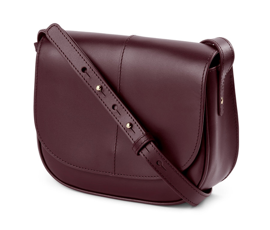 Detailaufnahme einer bordeauxroten Lederhandtasche »Saddle Bag« mit verstellbarem Riemen.