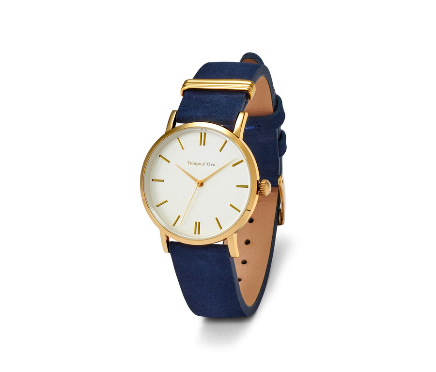 Nahaufnahme einer Damenuhr mit blauem Lederarmband und goldenem Zifferblatt.