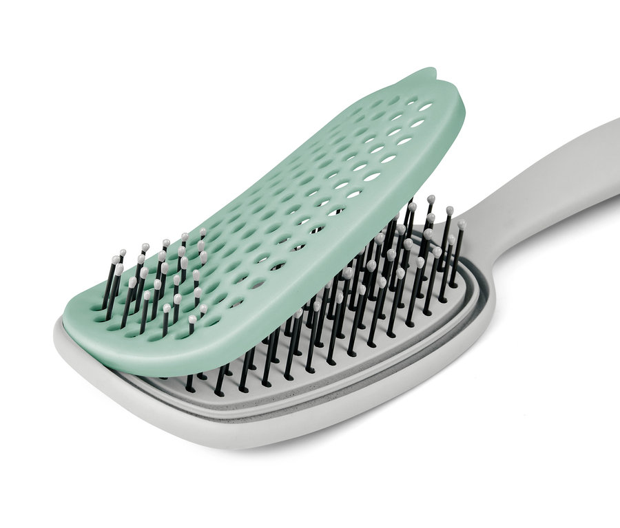 Eine Haarbürste mit Schutzauflage ist sichtbar.