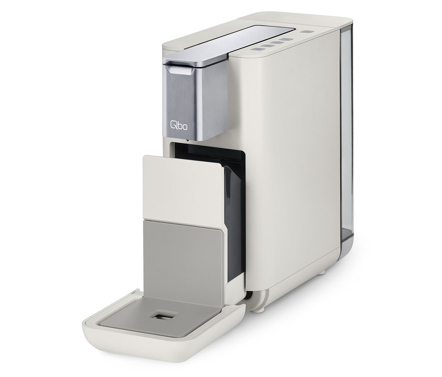 Qbo ESSENTIAL Bright Sand Kaffeemaschine mit offenem Kapselbehälter.