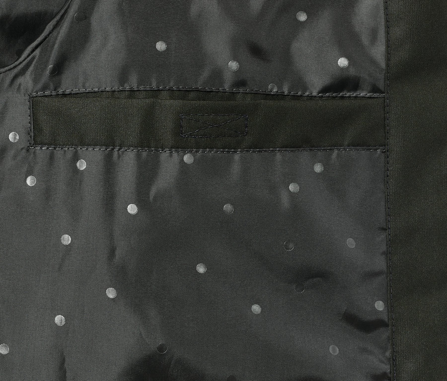 Detail einer Regenjacke mit Tasche und Punktmuster.