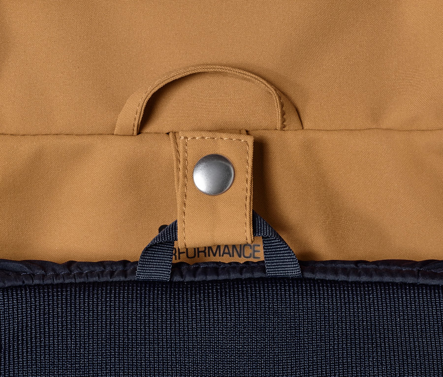 Detailansicht eines cognacfarbenen 3-in-1-Outdoormantels mit silbernem Druckknopf.