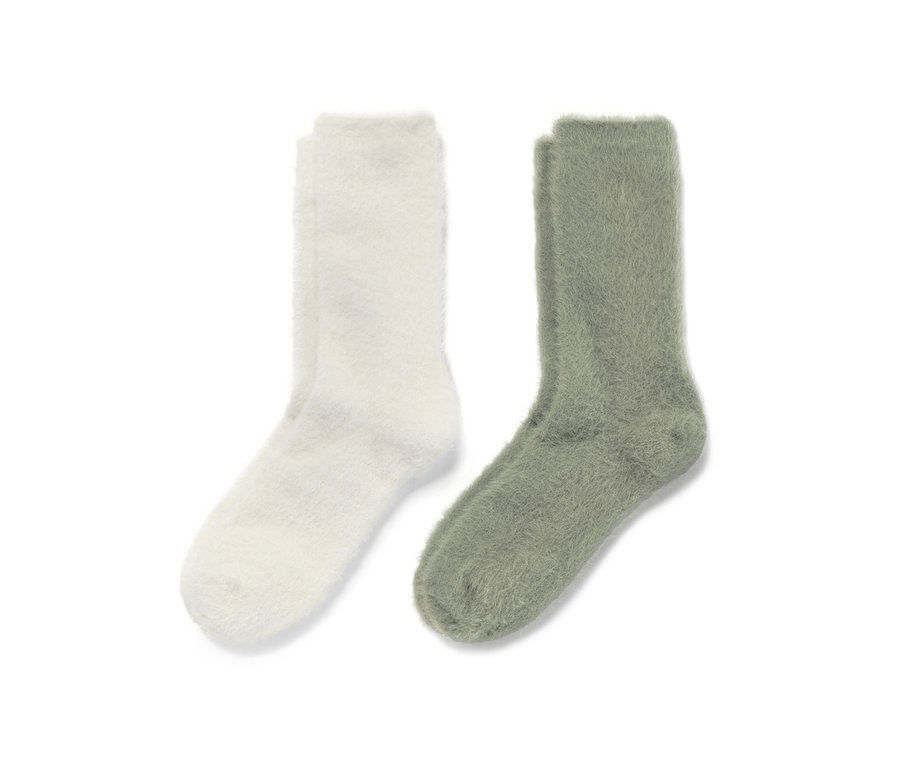 Zwei Paar flauschige Kuschelsocken mit Effektgarn in Creme und Grün.