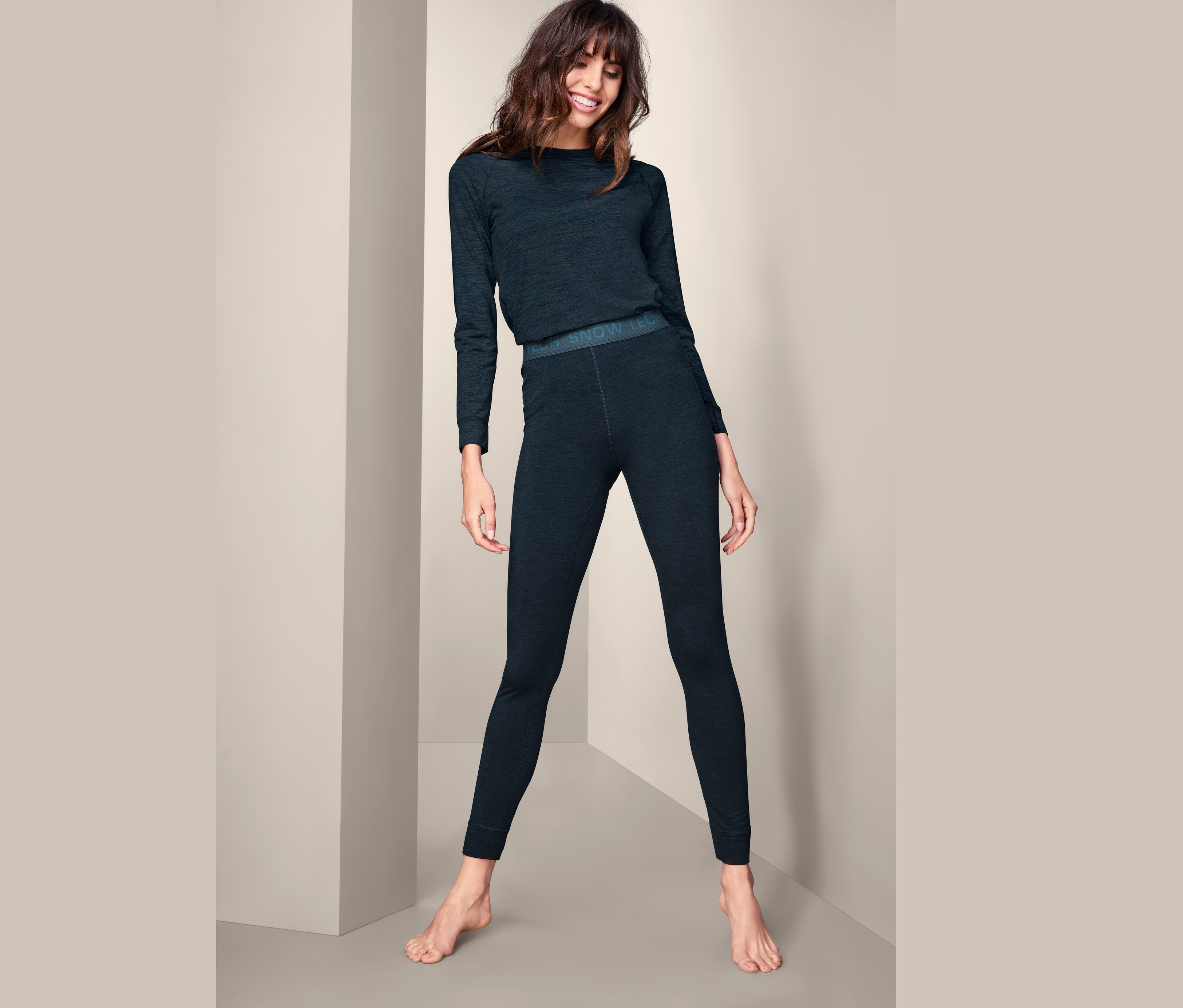 Frau trägt Funktionsunterhose mit Merinowolle und langärmliges Oberteil.