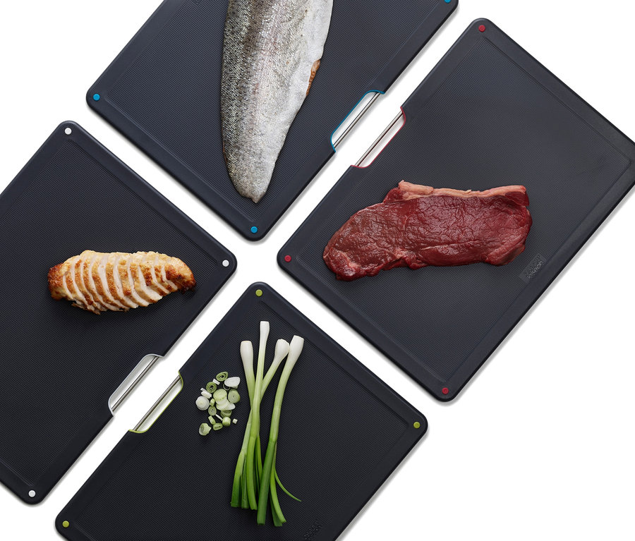 Vier Joseph Joseph Folio Schneidebretter mit Fisch, Rindfleisch, Hühnchen und Frühlingszwiebeln.