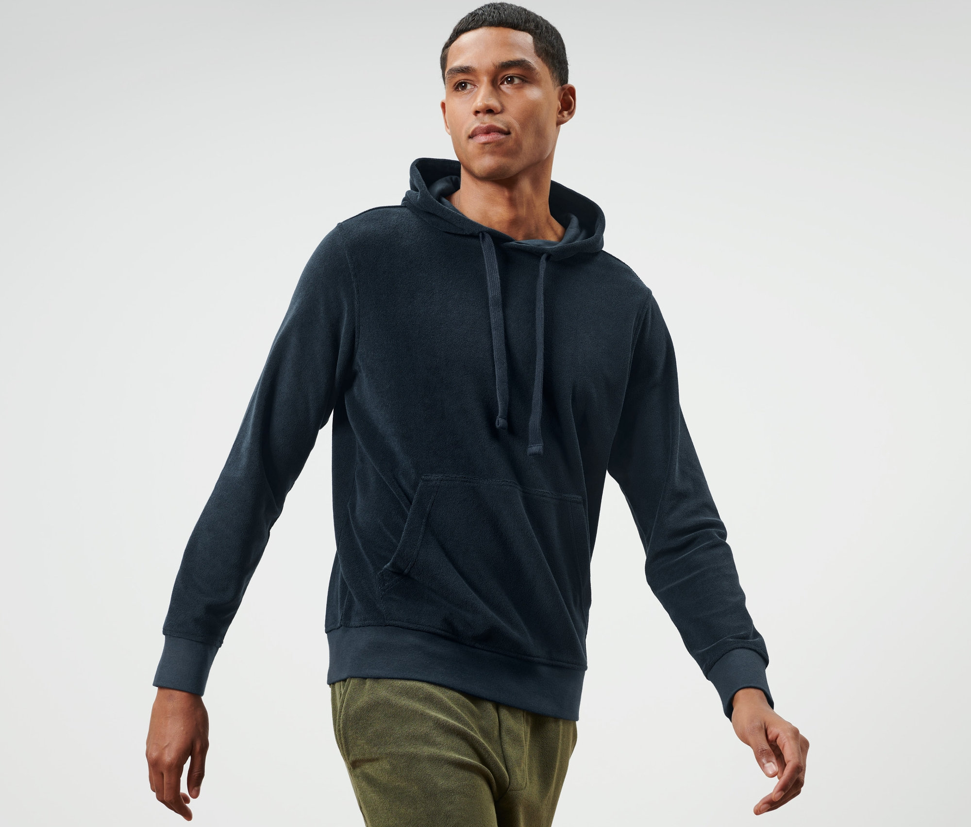 Mann geht und trägt einen Frottee-Hoodie.