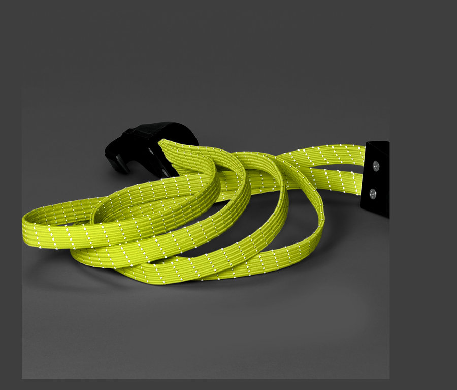 Ein grüner Fahrrad-Spanngurt mit schwarzer Schnalle auf grauem Hintergrund.