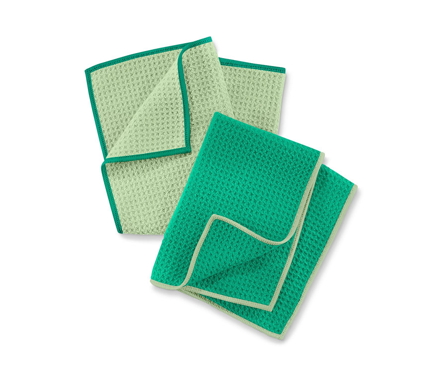 Zwei Geschirrtücher: ein hellgrünes mit dunkelgrüner Bordüre und ein grünes mit hellgrüner Bordüre.