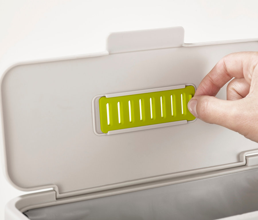 Eine Hand öffnet den Deckel des Joseph Joseph Küchenkomposters.