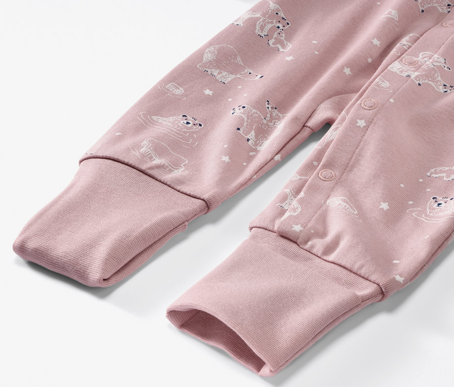Detailansicht eines rosa Baby-Schlafanzugs mit Eisbärenmuster.