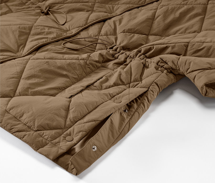 Detailansicht eines braunen Kapuzen-Stepp-Ponchos.