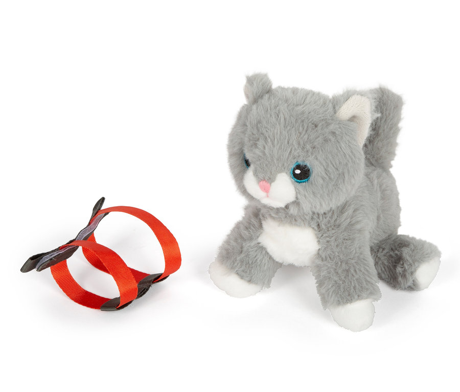 Eine graue small foot Stoffkatze mit Tasche und Pflege-Set liegt neben einer orangefarbenen Leine.