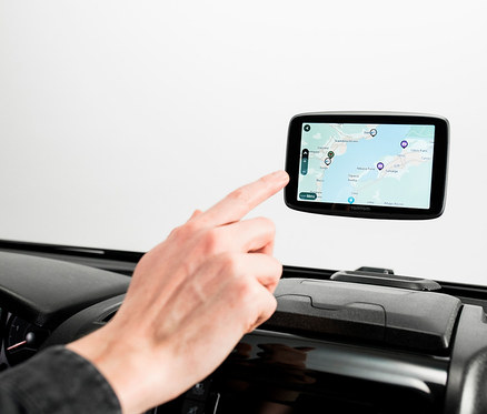Ein Finger berührt den Bildschirm eines TomTom GO Camper Tour im Auto.