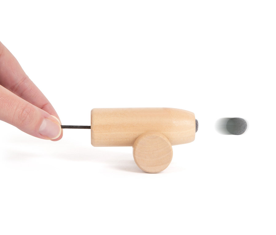 Eine Hand zieht an der Schnur einer hölzernen small foot Piratenkanone und feuert eine graue Kugel ab.