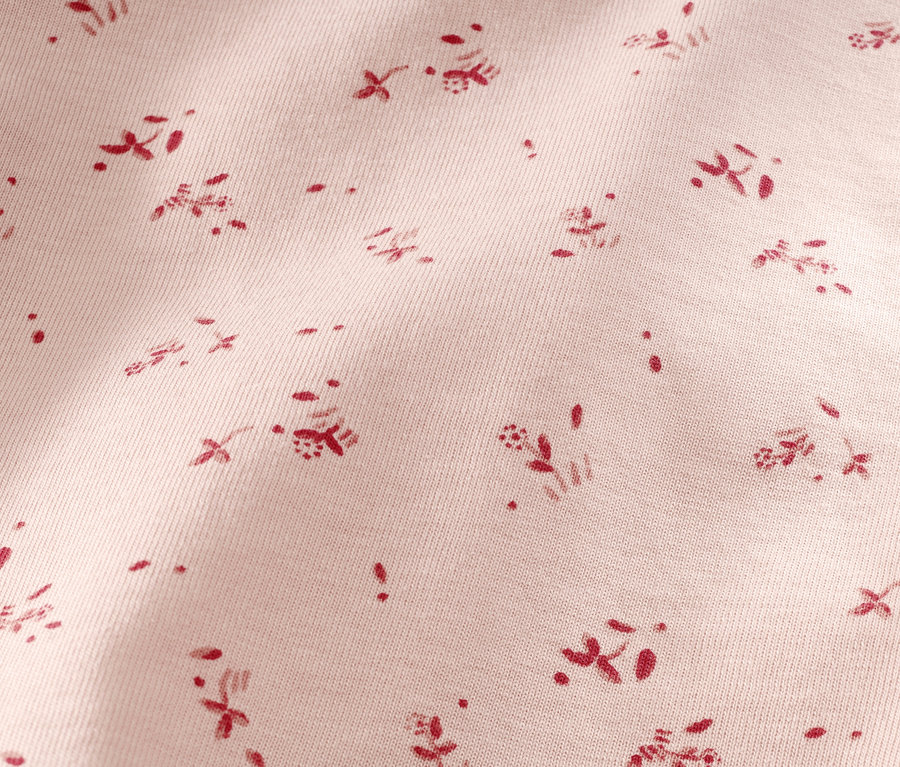 Detailaufnahme eines Kleinkind-Pyjamas mit kurzem Arm und Blumenmuster. 2 Kleinkind-Pyjamas, kurz, Blümchen.