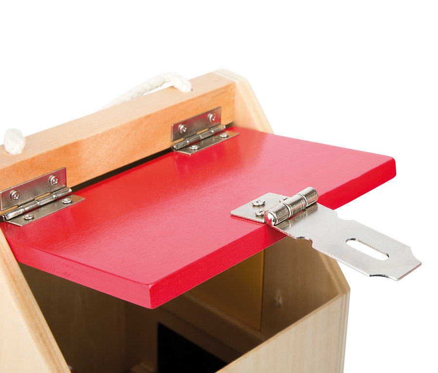 Detailansicht eines hölzernen small foot Schlosshaus mit roter Tür und silbernem Vorreiber.