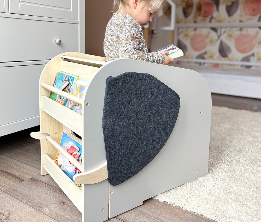 Kleinkind sitzt und schaut sich ein Buch in einer small foot Spielzeugbox Elefant »Wildlife« an.